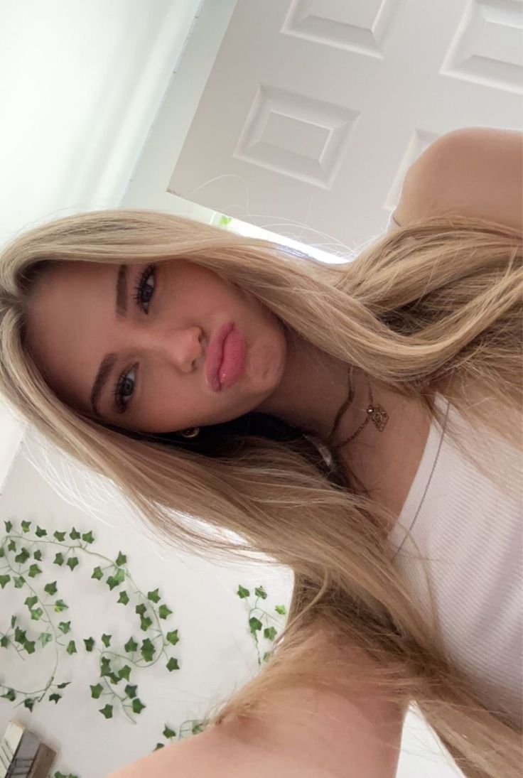 Blonde woman with kissy face and ivy background