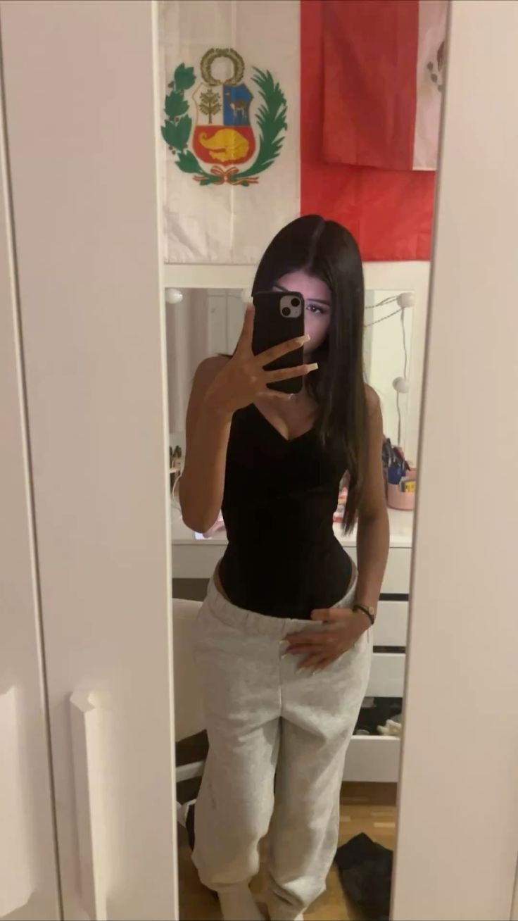 Mirror selfie, black top, grey sweatpants, Peruvian flag