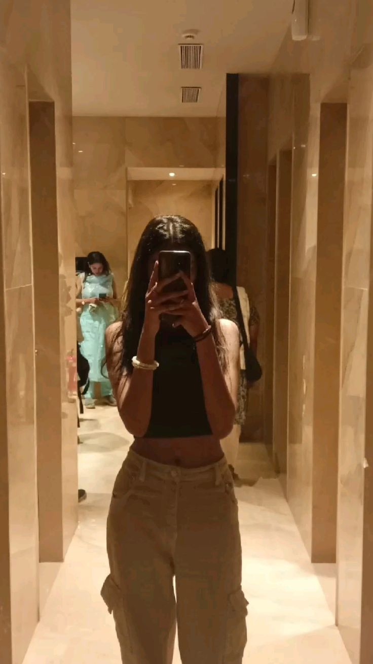Mirror selfie, black crop top, beige cargo pants, hallway