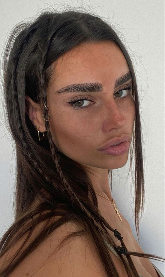 Close-up selfie of woman with braided hair and distinct makeup