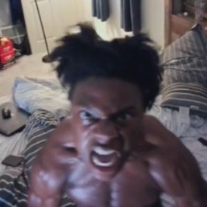 A shirtless man with wild hair, making an aggressive facial expression, looking directly at the camera