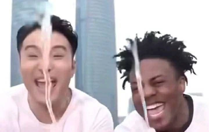Two people sharing a long noodle or spaghetti strand